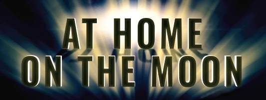 Poster title reading 'AT HOME ON THE MOON' with radiant light burst behind the letters.